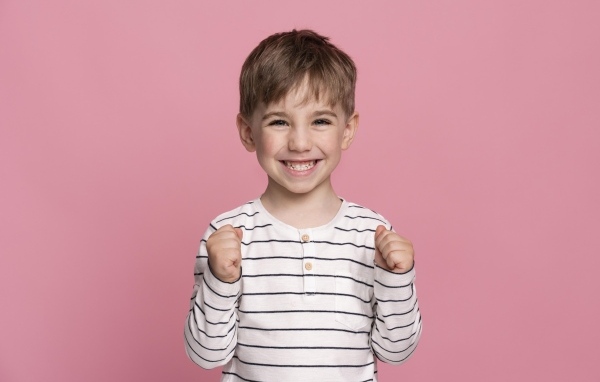 Улыбающийся маленький мальчик на сиреневом фоне
