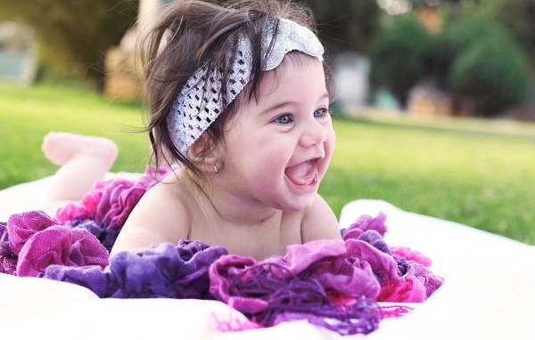 Улыбающаяся маленькая девочка с повязкой на голове 