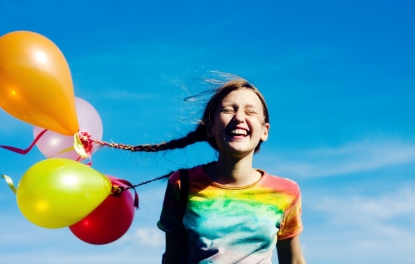 У веселой девочки шарики привязаны к косам