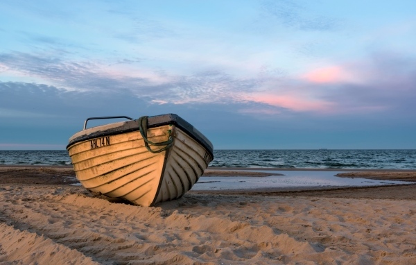 Лодка стоит на песке у моря летом