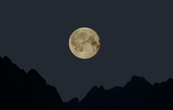 Большая белая луна над горами ночью 