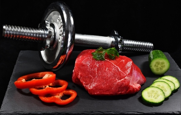 Dumbbell and healthy food for an athlete on a black background