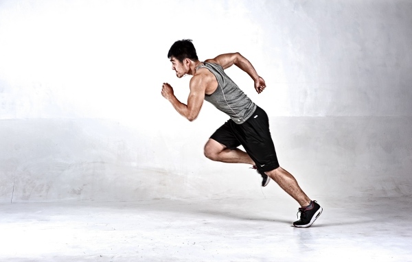 Мужчина бегун на сером фоне