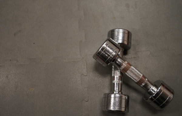 Две железные гантели на сером фоне