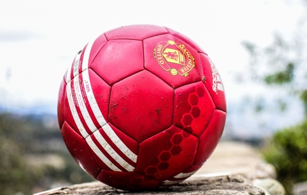 Красный футбольный мяч лежит на камне