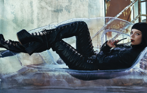 Актриса Аня Тейлор-Джой в черном костюме лежит на диване