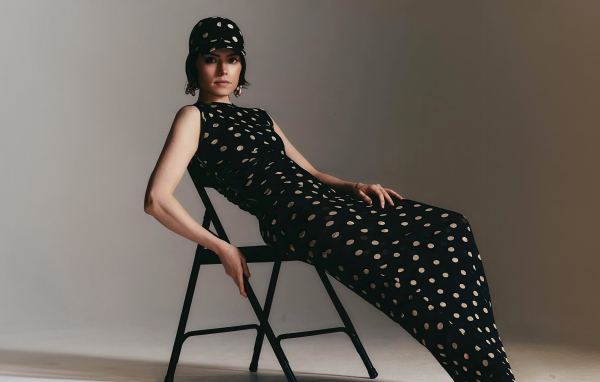 Актриса Дейзи Ридли в черном платье сидит на стуле