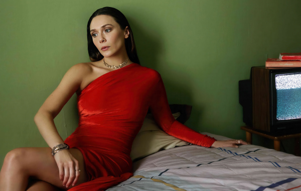 Актриса Элизабет Олсен в красном платье сидит на кровати