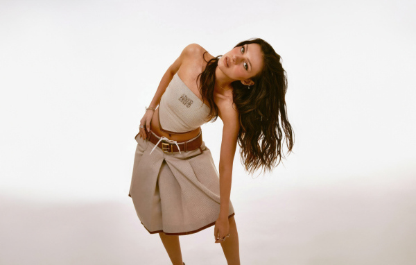 Актриса Никола Пельтц в юбке на сером фоне