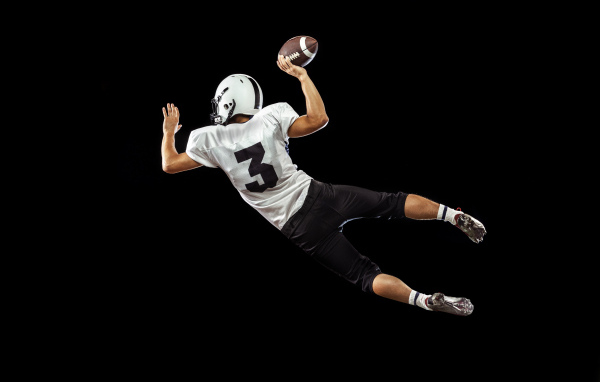 Игрок в американский футбол на черном фоне
