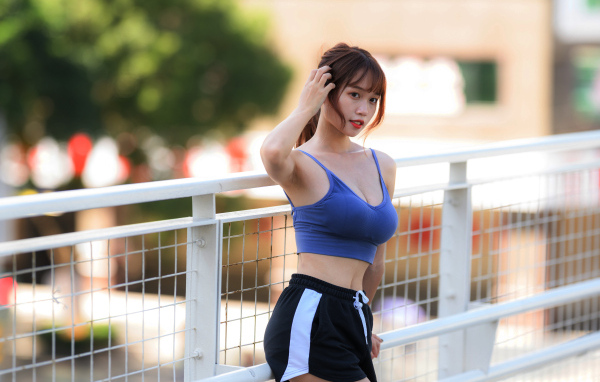 Спортивная азиатка с рукой в волосах