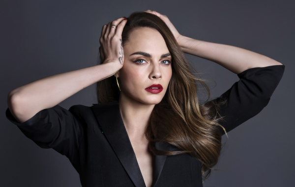 Красивая Кара Делевинь с руками на голове