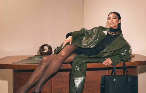 Канадская актриса Шэй Митчелл в плаще лежит на столе