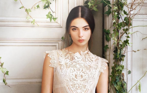 Милая девушка Дева Кассель стоит у стены