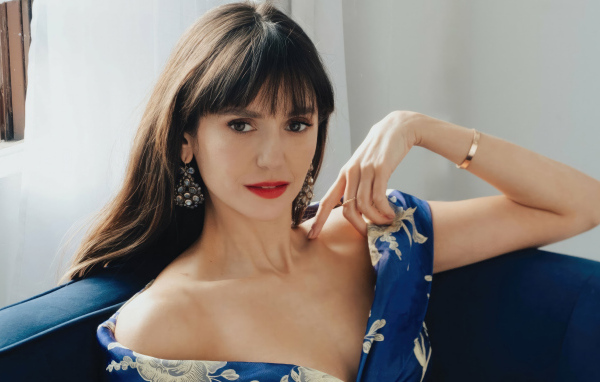 Милая девушка актриса Нина Добрев на диване