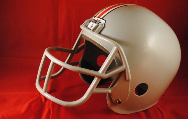 Шлем для игры в американский футбол на красном фоне