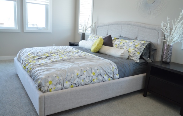 Большая мягкая кровать в серой спальне