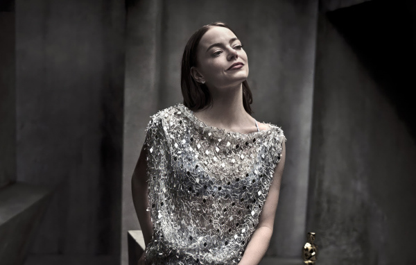 Рыжеволосая актриса Эмма Стоун в блестящем платье в серой комнате