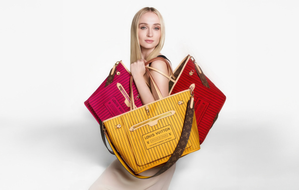 Софи Тернер с сумками Луи Виттон на белом фоне