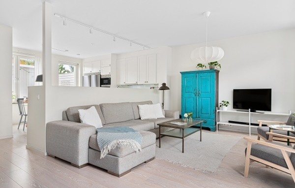 Просторная гостиная комната  с серым диваном