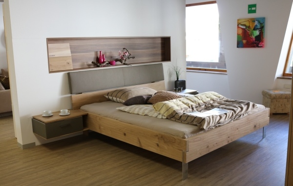 Деревянная кровать на ножках в спальне