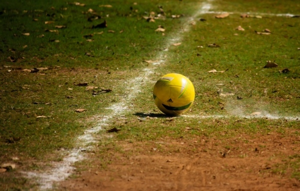 Желтый мяч на футбольном поле осенью 