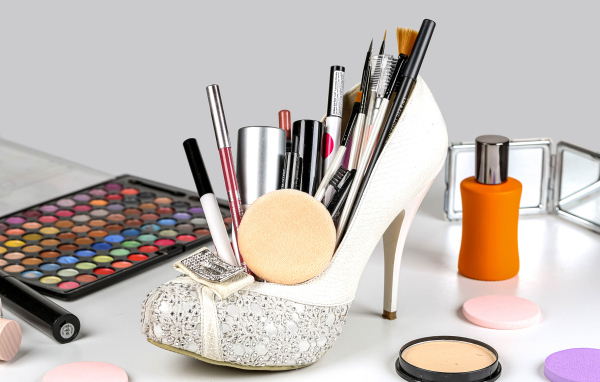 Женские белые туфли наполнены косметикой