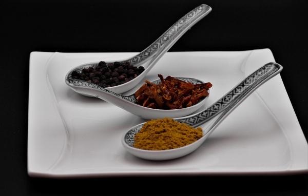 Ароматные специи в ложках на белой тарелке