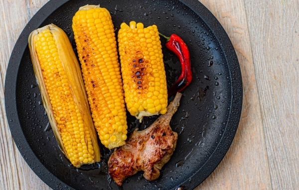 Запеченная кукуруза с ребрышками на тарелке