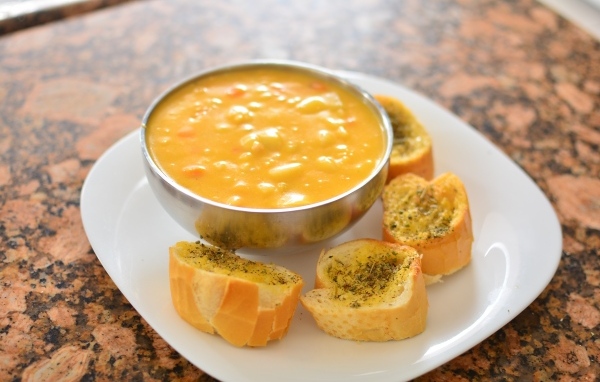 Суп с фасолью на тарелке с гренками