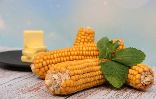 Початки кукурузы на столе с маслом