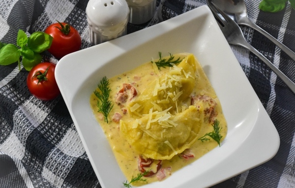 Равиоли с соусе с беконом на тарелке