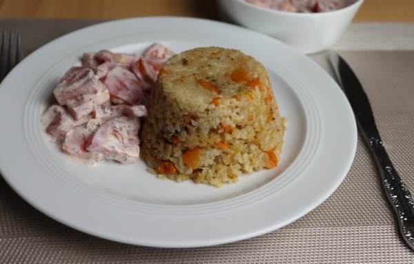 Рис с салатом на большой белой тарелке