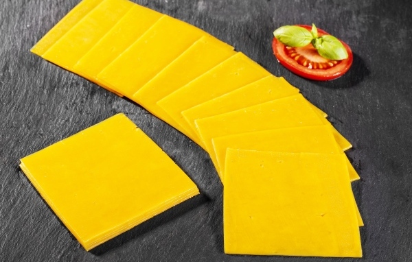 Ломтики сыра с помидором на столе