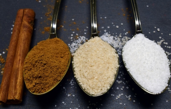 Три ложки со специями на сером столе