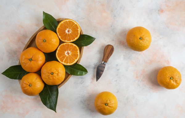 Крупные апельсины на столе с ножом