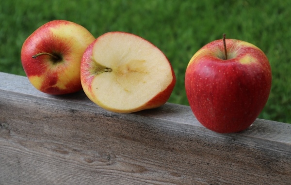 Красные яблоки лежат на деревянной доске