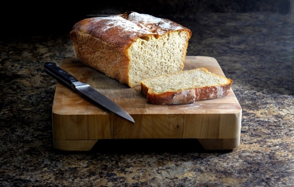 Буханка хлеба с ножом на столе