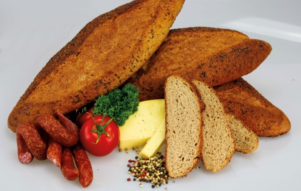 Свежая выпечка на столе с колбасой, сыром и помидорами