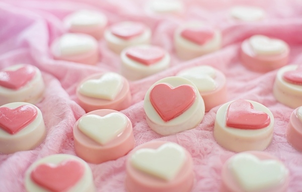 Конфеты с сердечками на розовой поверхности