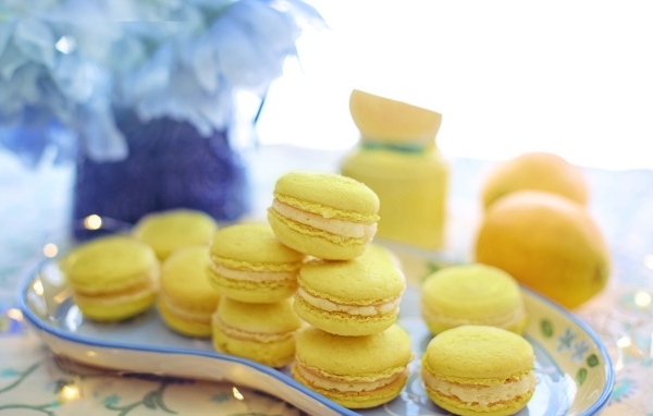 Десерт макарунс желтого цвета на тарелке на столе