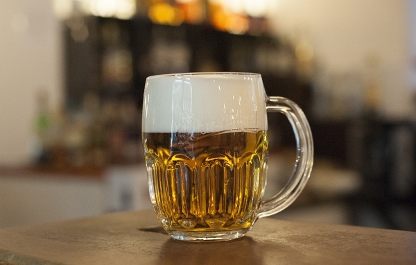 Бокал пива с пеной на столе