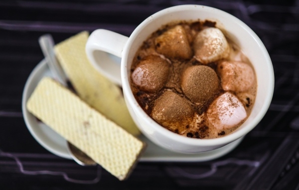 Чашка какао с маршмеллоу на тарелке с вафлями