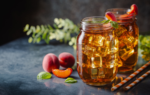 Холодный чай со льдом на столе с абрикосами