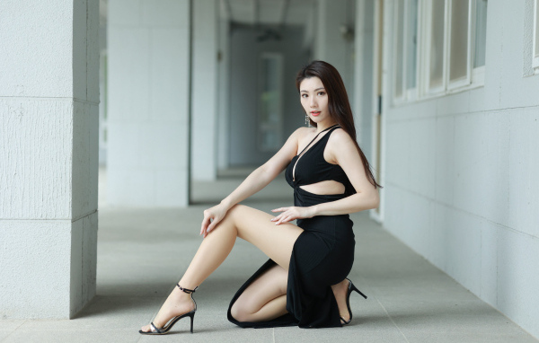 Девушка азиатка в черном наряде позирует для фото
