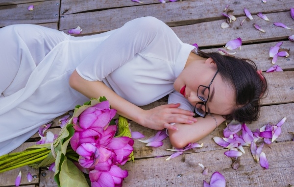 Девушка азиатка лежит с цветами лотоса
