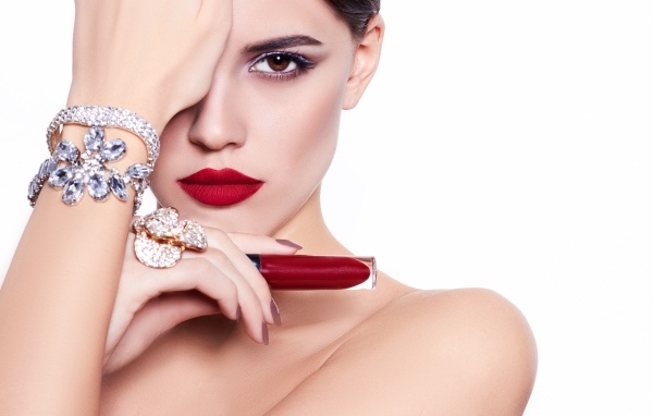 Красивая девушка с красной губной помадой в руке