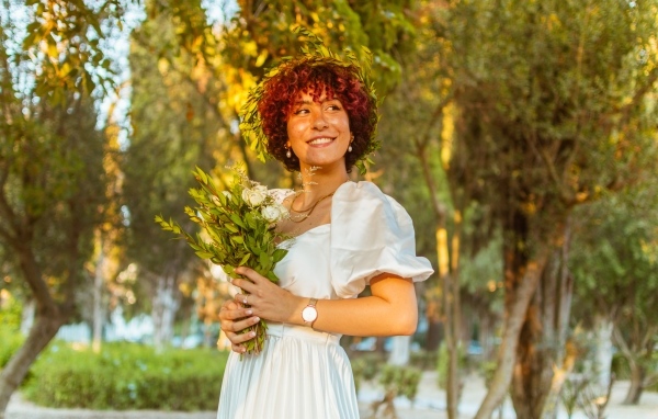 Красивая улыбающаяся рыжеволосая девушка с букетом