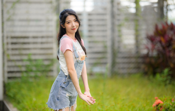Милая девушка азиатка в джинсовом комбинезоне