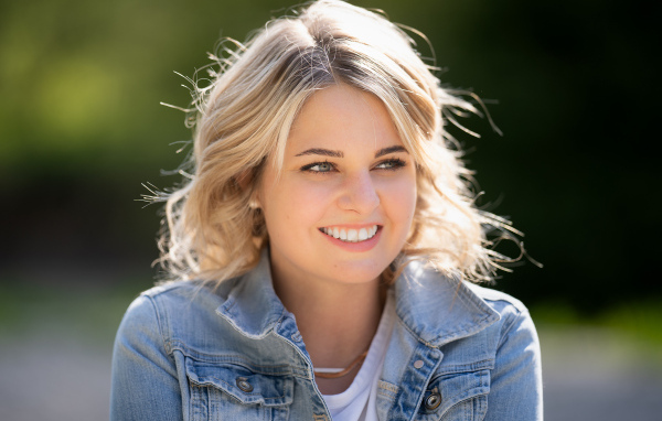 Улыбающаяся блондинка с красивыми белыми зубами